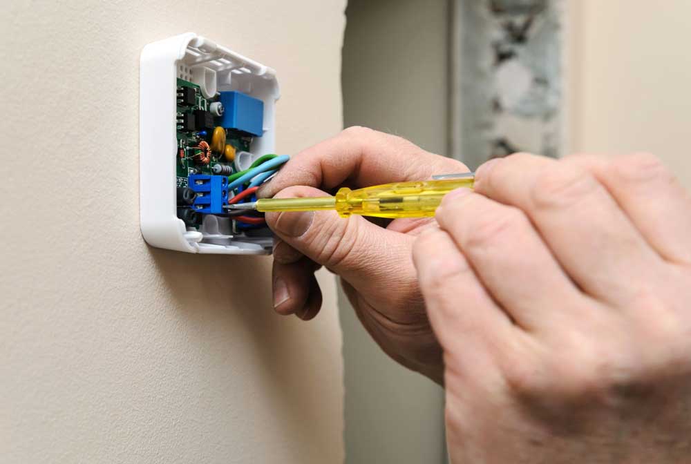Technician performing thermostat repair Decatur GA in residential home